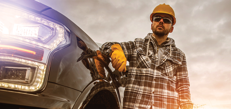 construction worker leaning on pickup truck 