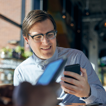 A man wearing glasses talking on a cell phone.