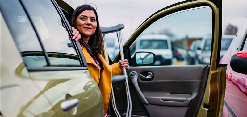 Woman with cast getting out of car