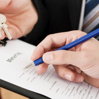Man signing lease paperwork.