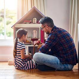 dad and daughter playing with dollhouse