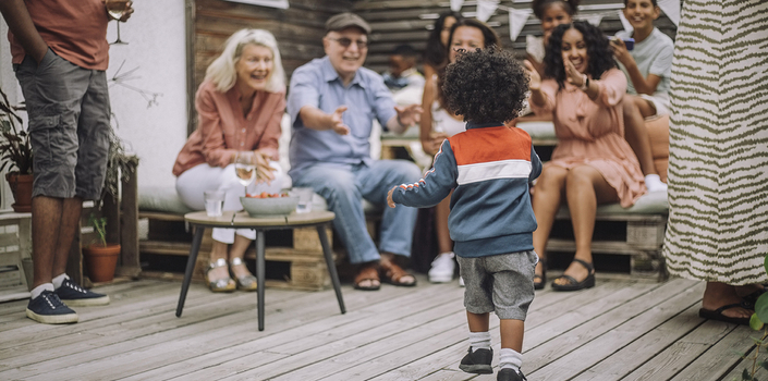 Rear view of boy walking at porch during party