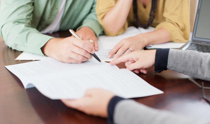 Signing a document on a table.