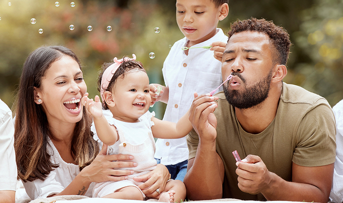 Parents and grandparents blowing bubbles with two small children