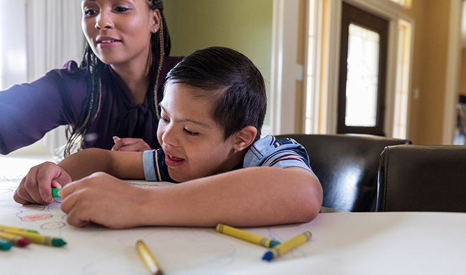 Mother and son coloring at a table.