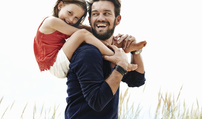 Dad carrying daughter on shoulders.