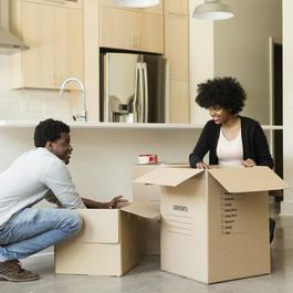 Couple unpacking boxes in new apartment.