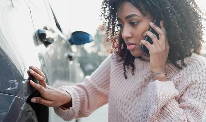 Woman examining car damage
