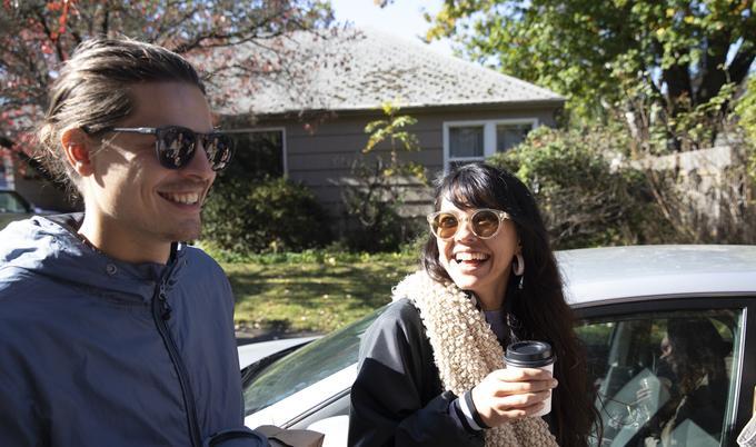 man and woman smiling with their food and drinks