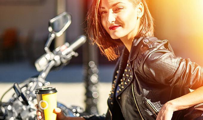 woman drinking coffee on motorcycle
