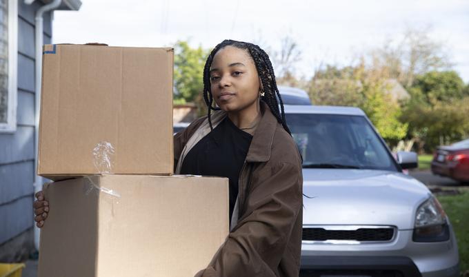 black female bring movingboxed  from car to house