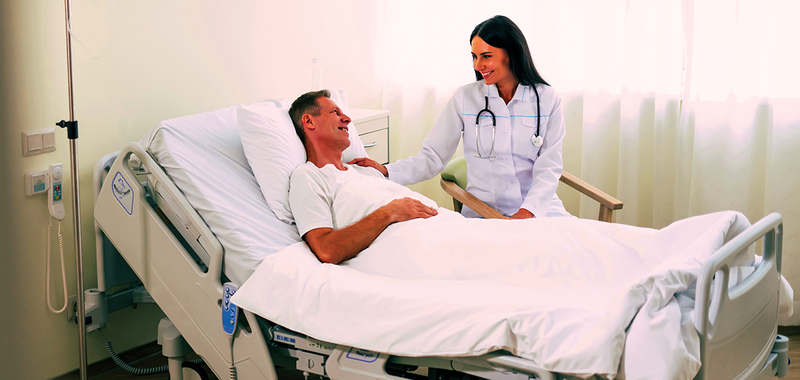 doctor attending to patient in hospital bed 