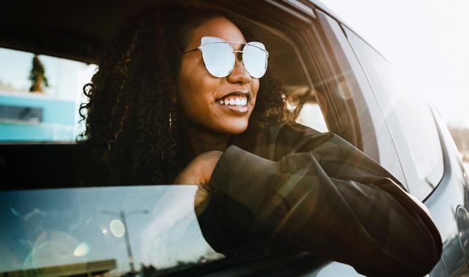 Group of young adults having fun riding in car.