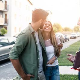 Realtor speaking to couple outside of rental unit.