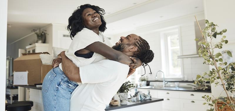 happy couple celebrating in living room of home 