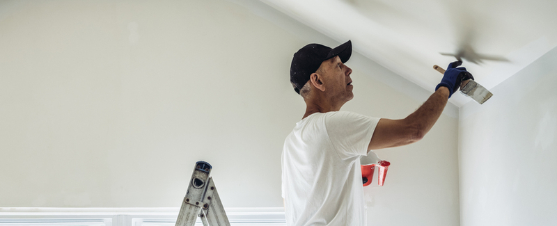 Senior man painting apartment interior