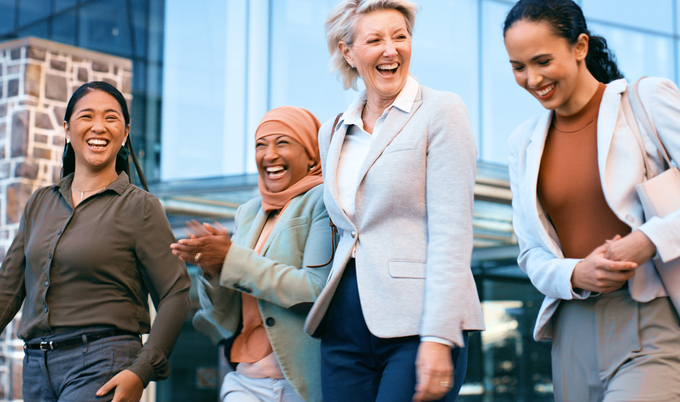 A diverse group of women walking together outside an office building