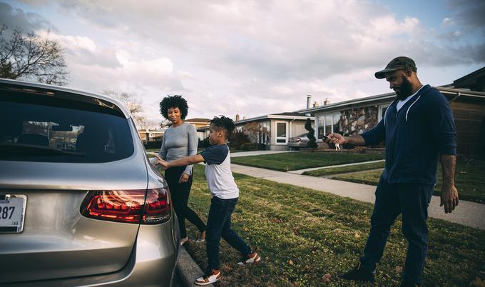 Family getting into car in front of house