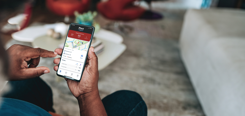 A man uses his smartphone while sitting in a living room.