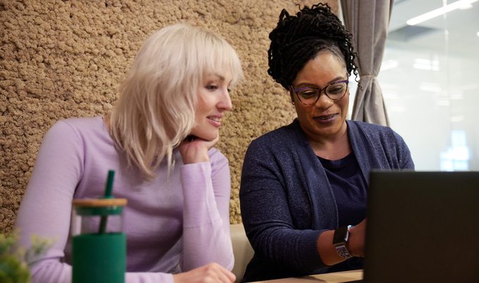 a person sitting at a table using a laptop computer
