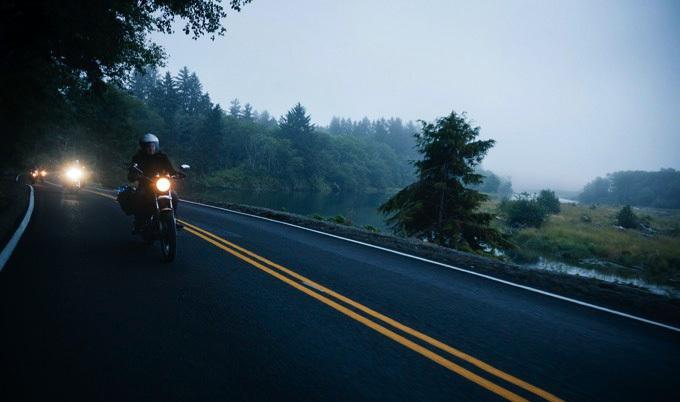 Motorcylce riders riding down a country road.