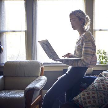  Blond woman on laptop living room