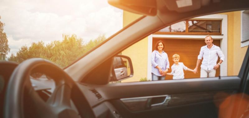A young family walks out from their house to their car