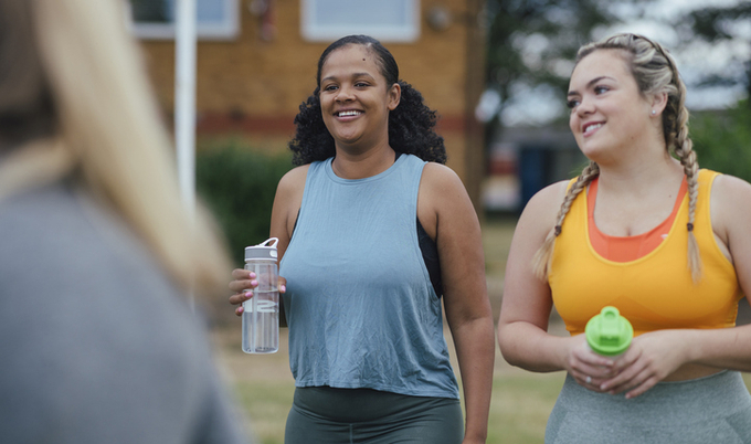 Two women out for a walk holding water bottles.